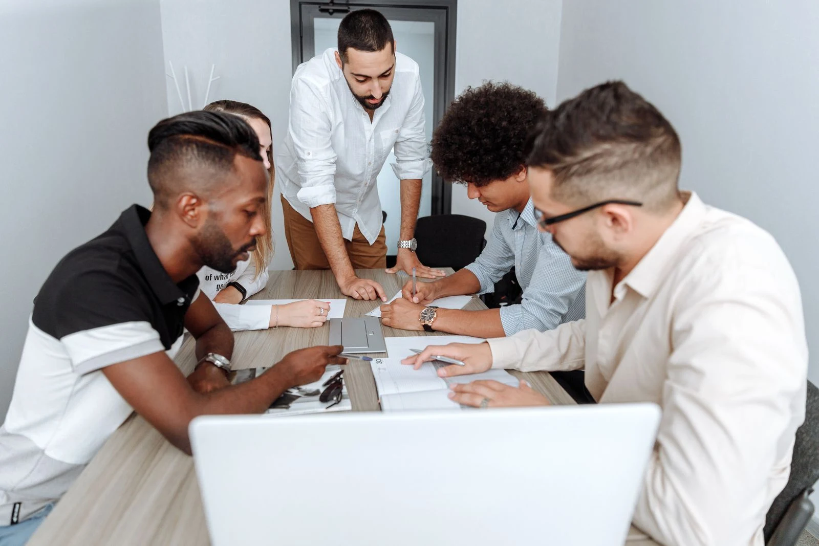 Business professionals reviewing documents together around an office table